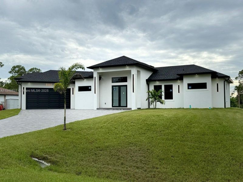 Front exterior of a new home in , Lehigh Acres, FL, highlighting curb appeal (Image 1).