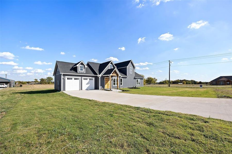 View of front of house featuring a front yard and a garage