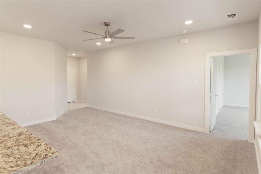 Carpeted spare room featuring ceiling fan