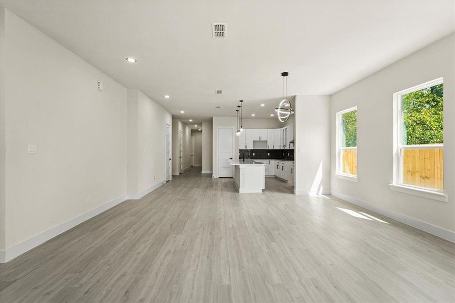 Unfurnished living room featuring recessed lighting and light wood finished floors Unfurnished living room featuring recessed lighting and light wood finished floors