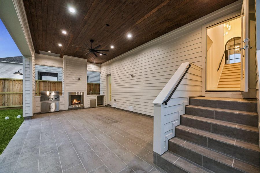 Large covered Lanai with a Gas Fireplace, Stainless Steel Grill, Stainless Steel Sink, Slab Quartz Counter and Electrical Connection for a Beverage Center. The Lanai ceiling is finished with Tongue and Groove Stained Wood and a Ceiling Fan. The patio floor is completed with a stamped smooth texture concrete.