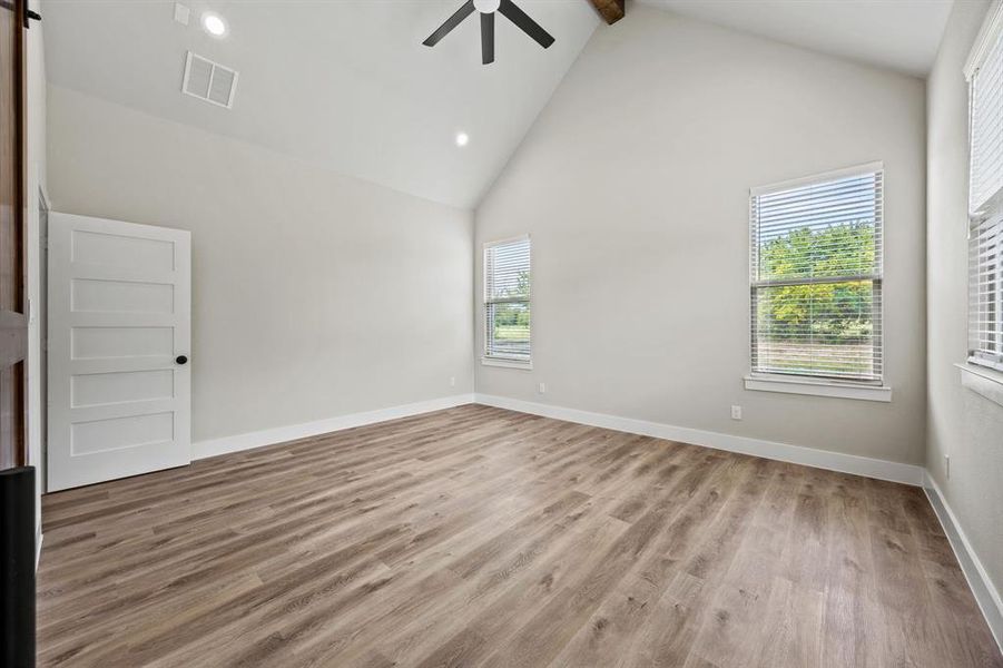 Unfurnished room with high vaulted ceiling, light wood-style flooring, recessed lighting, beam ceiling, and ceiling fan Unfurnished room with high vaulted ceiling, light wood-style flooring, recessed lighting, beam ceiling, and ceiling fan