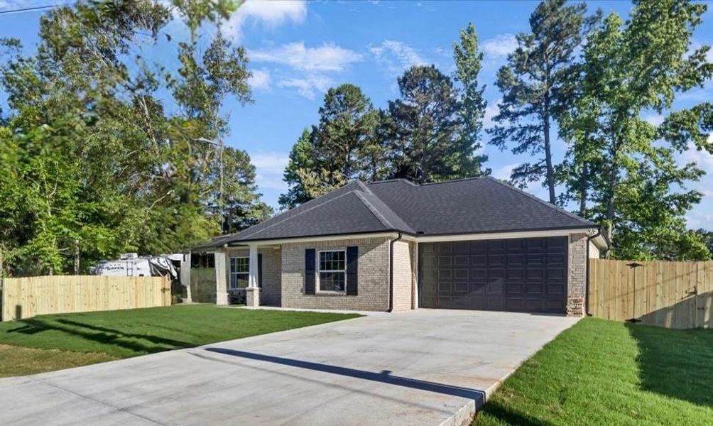 Single story home with a garage, concrete driveway, brick siding, and a shingled roof