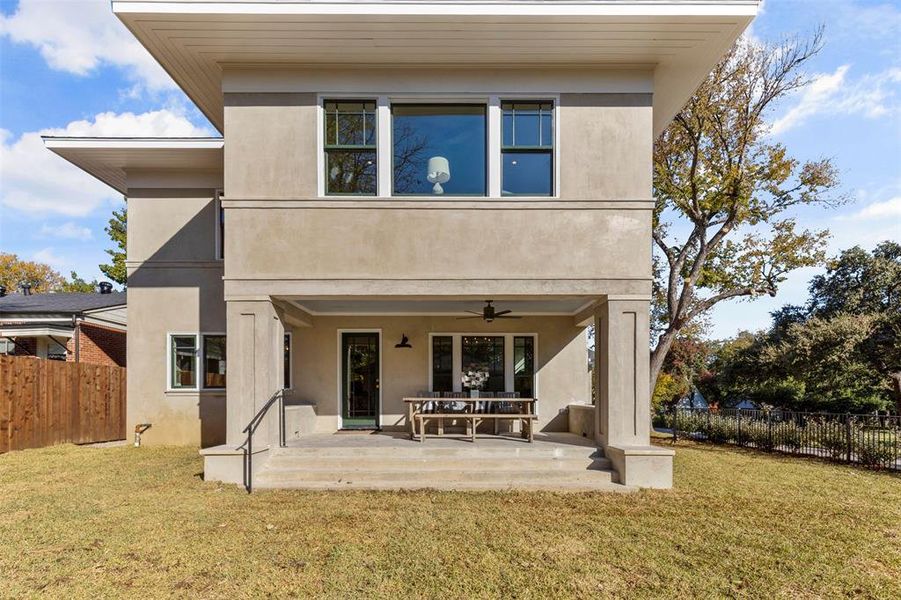 Back of property featuring ceiling fan, a lawn, and a patio