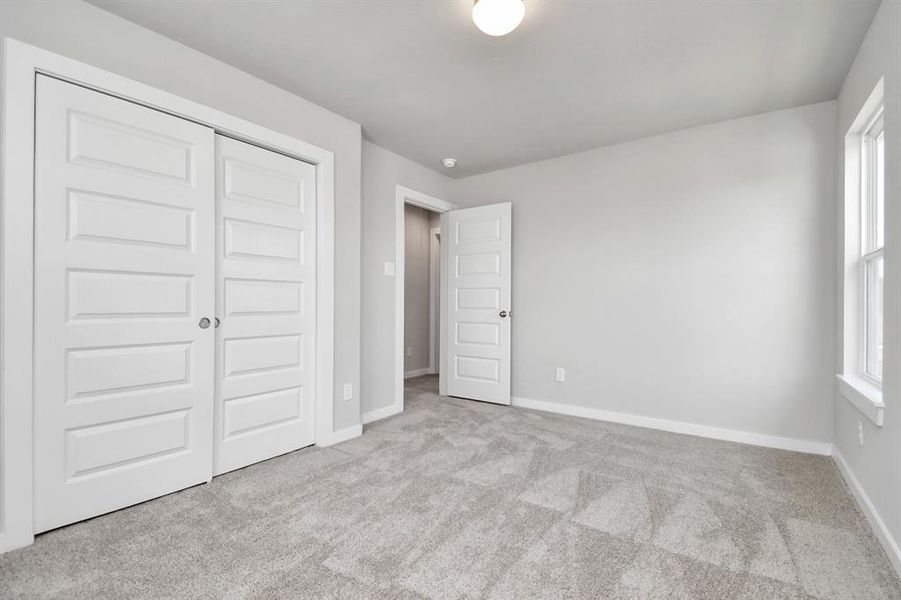 Generously sized secondary bedrooms, complete with spacious closets and soft, inviting carpeting. Enjoy abundant natural light streaming in through the large windows. Sample photo of completed home with similar floor plan. Actual colors and selections may vary.