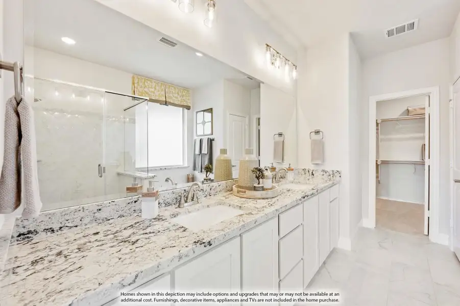 Master bathroom with double vanity, granite countertops, glass shower, and walk-in closet entrance