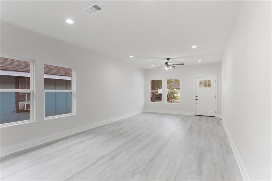 Unfurnished living room with light hardwood / wood-style floors and ceiling fan