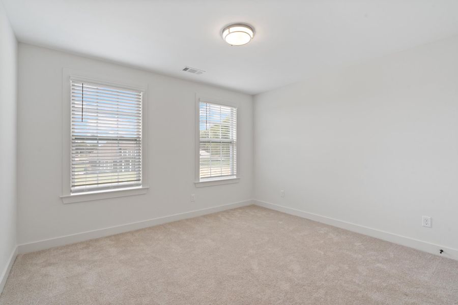 Neutral wall paint, plush carpeting, two windows, and overhead lighting Neutral wall paint, plush carpeting, two windows, and overhead lighting