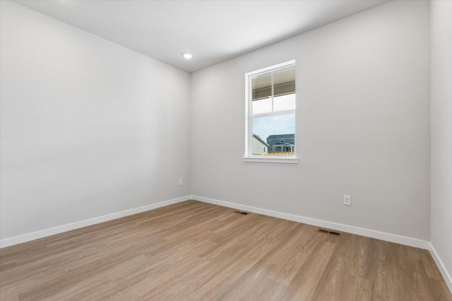 A room with a wood floor and a window.