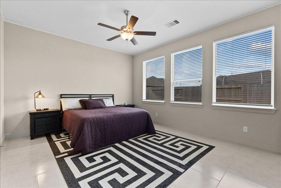 The expansive primary suite features three large windows that fill the room with natural light, showcasing the incredible size and creating a bright, welcoming space to unwind. The expansive primary suite features three large windows that fill the room with natural light, showcasing the incredible size and creating a bright, welcoming space to unwind.