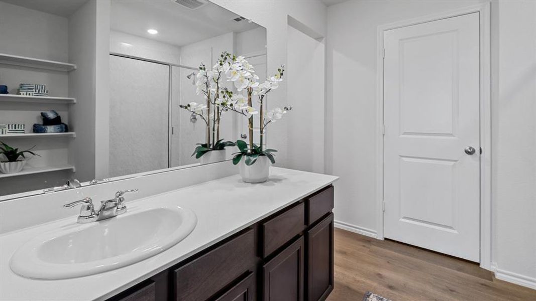 Bathroom with a stall shower, vanity, and dark wood-style flooring Bathroom with a stall shower, vanity, and dark wood-style flooring