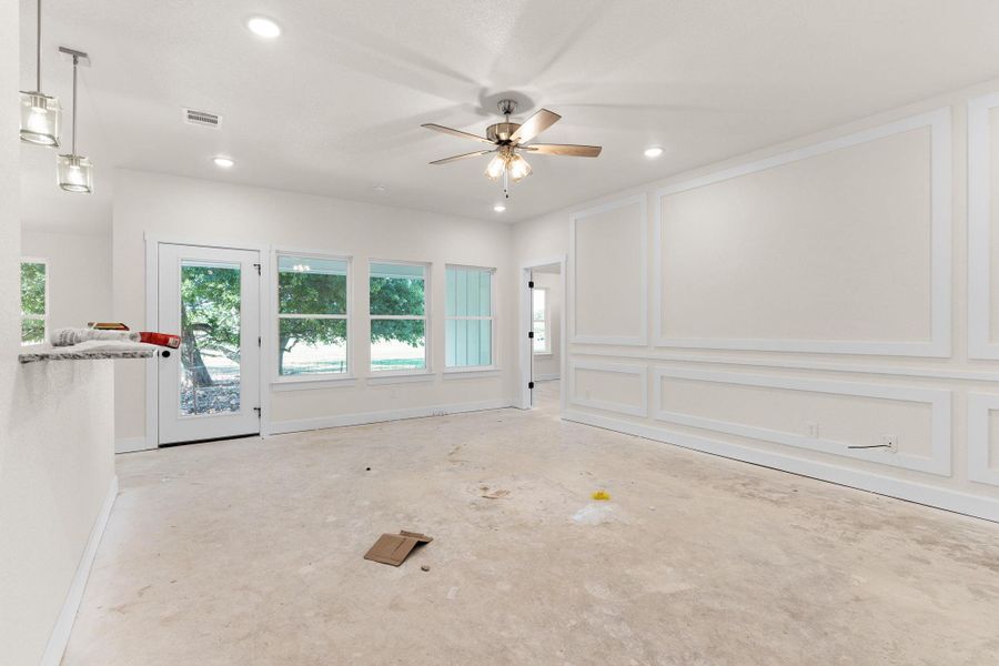 Unfurnished living room featuring plenty of natural light, a ceiling fan, recessed lighting, and concrete flooring Unfurnished living room featuring plenty of natural light, a ceiling fan, recessed lighting, and concrete flooring