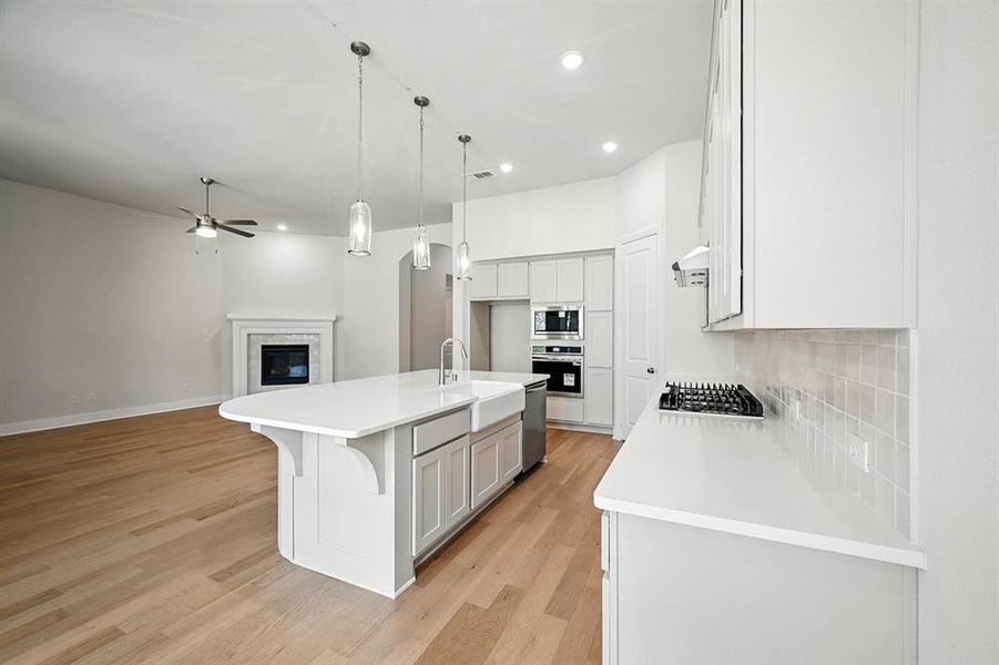 Kitchen with recessed lighting, an island with sink, open floor plan, light wood finished floors, and ceiling fan Kitchen with recessed lighting, an island with sink, open floor plan, light wood finished floors, and ceiling fan