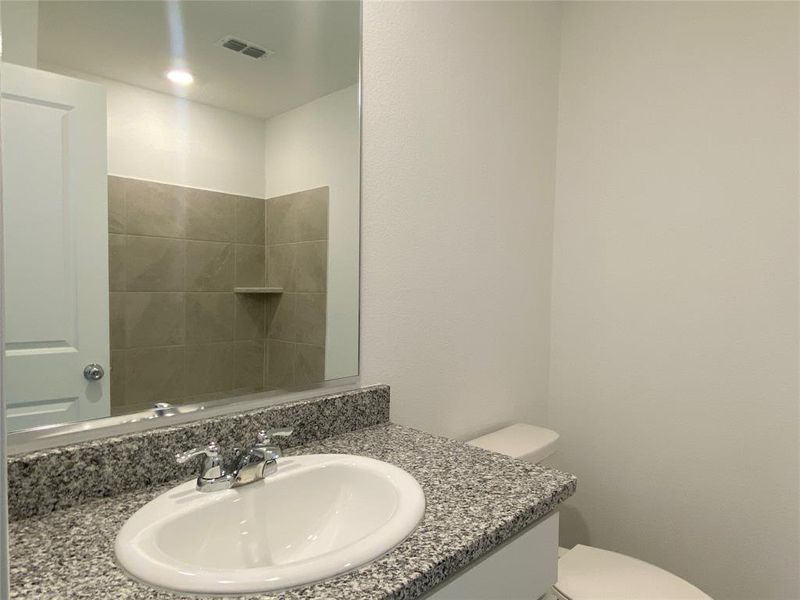 Bathroom with visible vents, vanity, and toilet