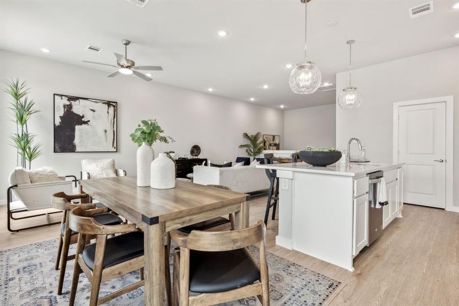 Dining space with sink, light wood-type flooring, and ceiling fan