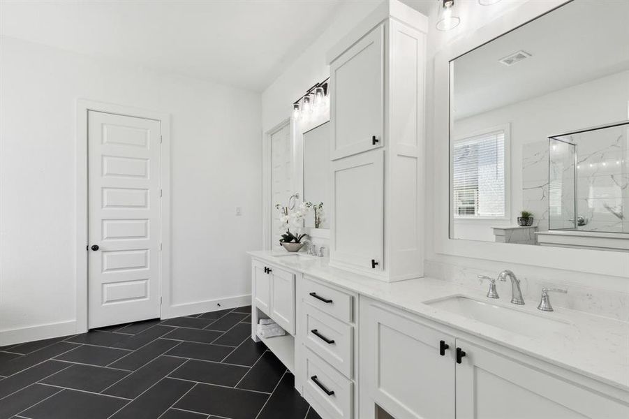 Bathroom featuring tile patterned floors, a shower with shower door, and vanity