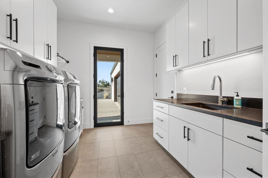Washroom with light tile patterned flooring, independent washer and dryer, recessed lighting, a sink, and cabinet space Washroom with light tile patterned flooring, independent washer and dryer, recessed lighting, a sink, and cabinet space
