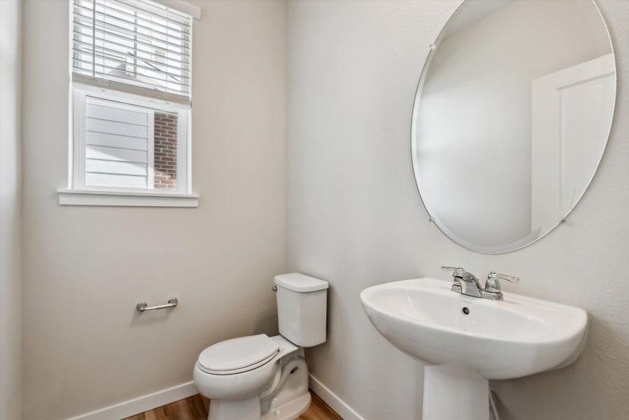 A bathroom with a round mirror.