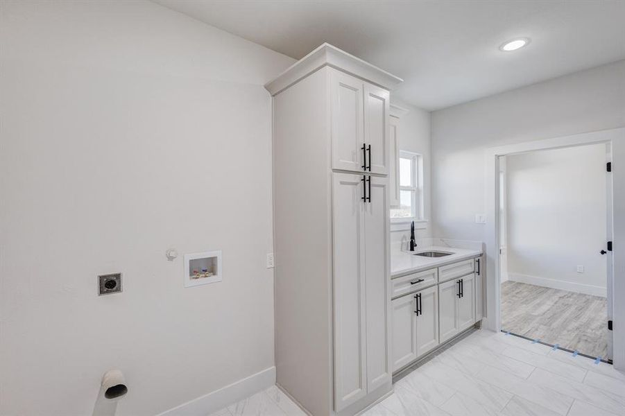 Laundry room with sink, cabinets, electric dryer hookup, hookup for a gas dryer, and hookup for a washing machine