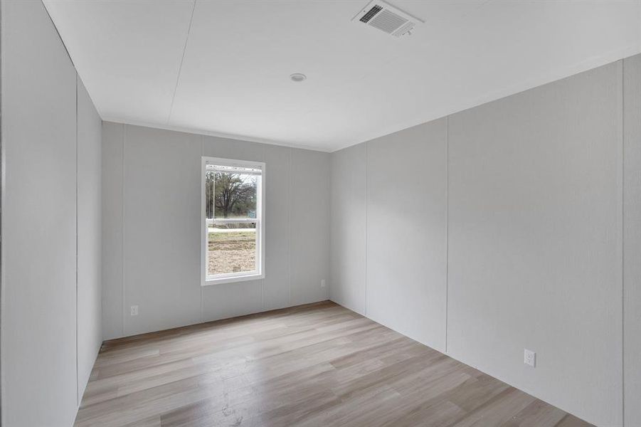 Spare room featuring a decorative wall and light wood-style flooring