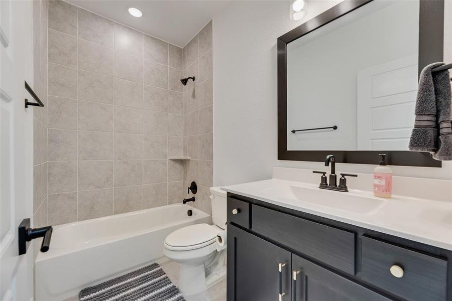 Full bathroom featuring bathing tub / shower combination, vanity, light tile patterned flooring, and recessed lighting
