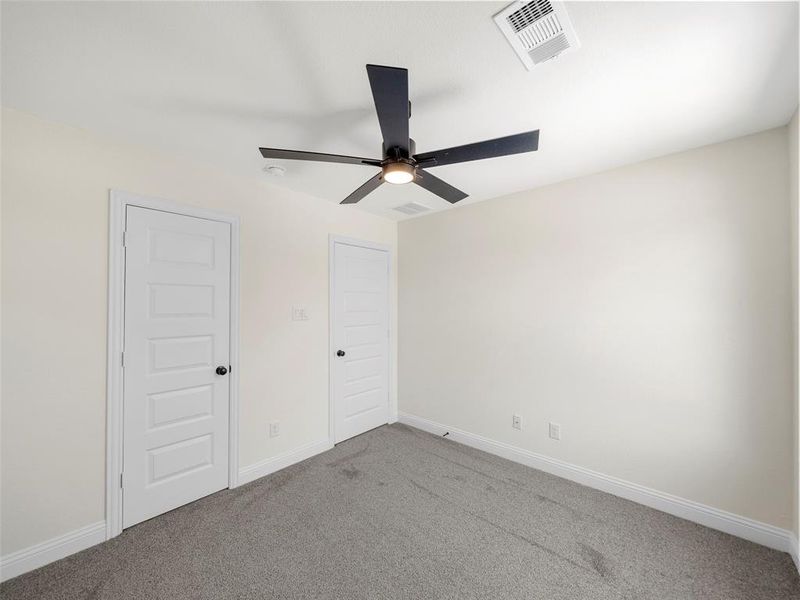 Carpeted empty room with ceiling fan