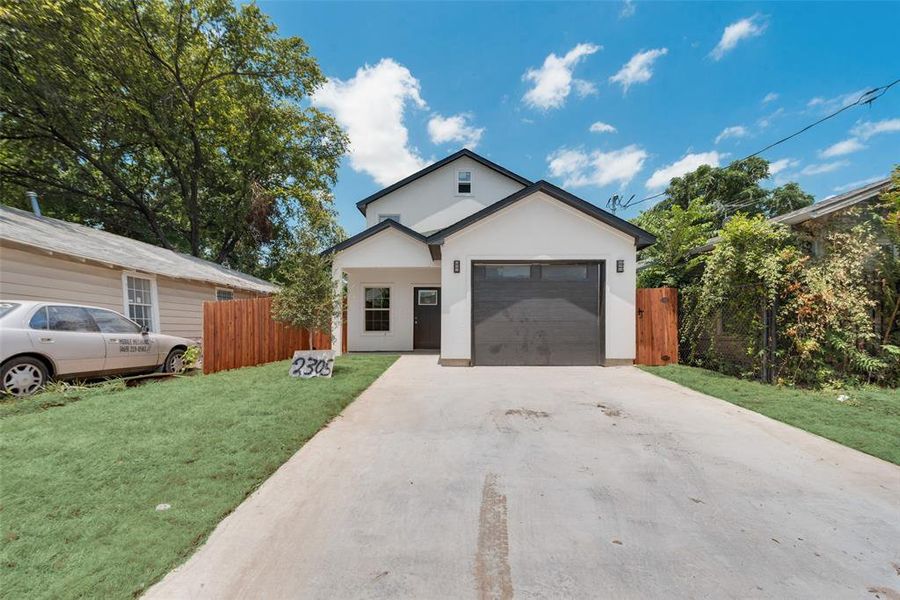 View of front of house with a garage and a front yard