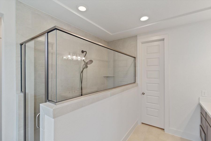 Full bathroom featuring a shower stall, vanity, recessed lighting, and light tile patterned floors