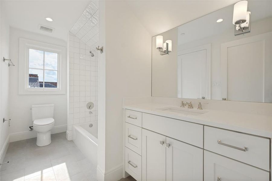 Spacious Jack and Jill bathroom featuring a functional tub/shower combination and generous counter space. Spacious Jack and Jill bathroom featuring a functional tub/shower combination and generous counter space.