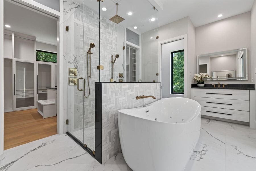 Luxurious walk-in shower with frameless glass and floor-to-ceiling tile.