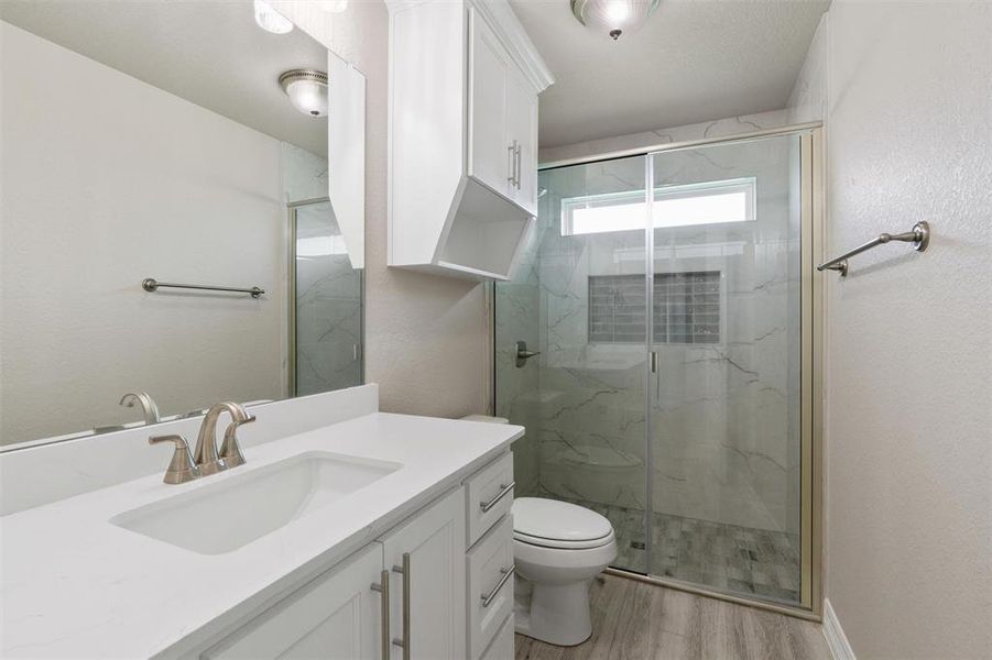 Bathroom featuring a single vanity with white cabinetry, a rectangular undermount sink, and a brushed nickel faucet Bathroom featuring a single vanity with white cabinetry, a rectangular undermount sink, and a brushed nickel faucet