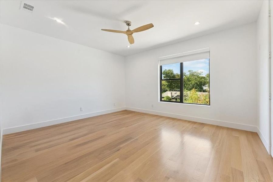 Spare room with light wood finished floors, a ceiling fan, and recessed lighting