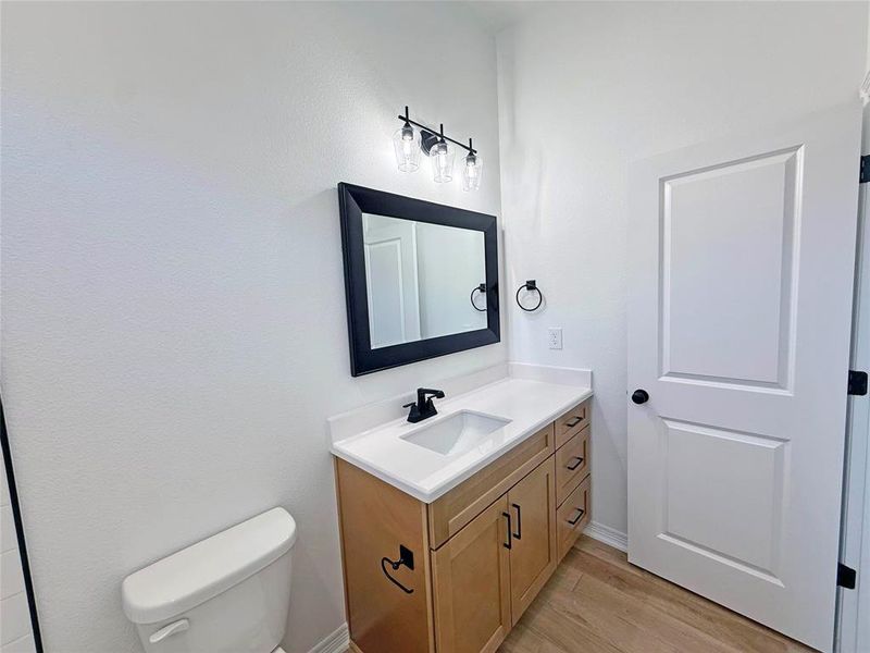 Half bath with vanity and light wood finished floors