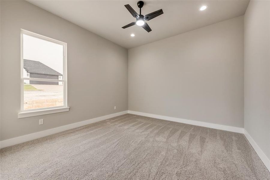 Carpeted spare room featuring ceiling fan