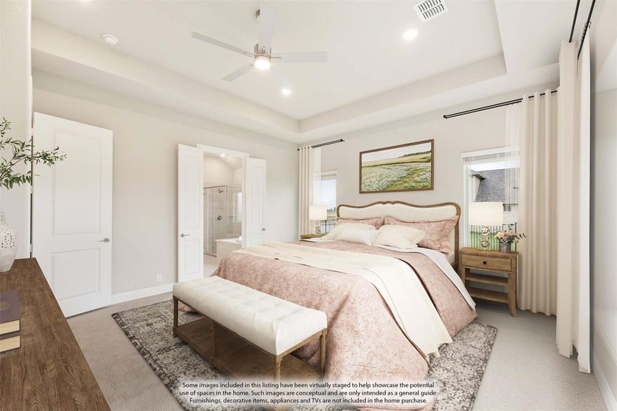 Primary bedroom with tray ceiling, ceiling fan, ensuite bathroom access, and neutral carpet flooring