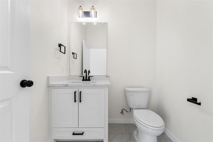 Bathroom featuring vanity and light marble finish flooring