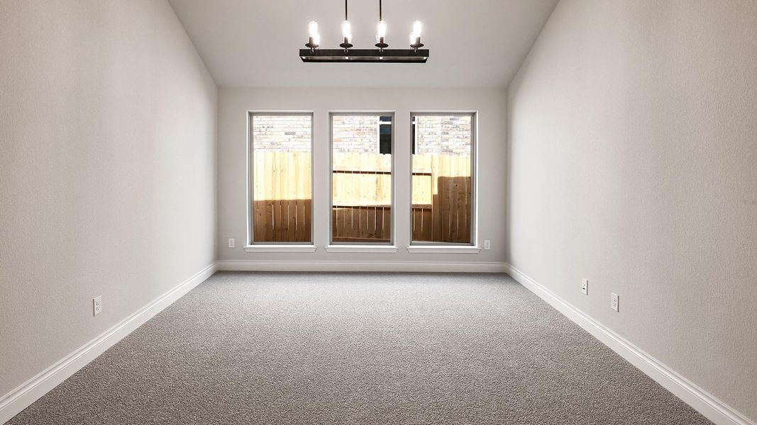Empty room featuring baseboards, carpet floors, vaulted ceiling, and a chandelier Empty room featuring baseboards, carpet floors, vaulted ceiling, and a chandelier
