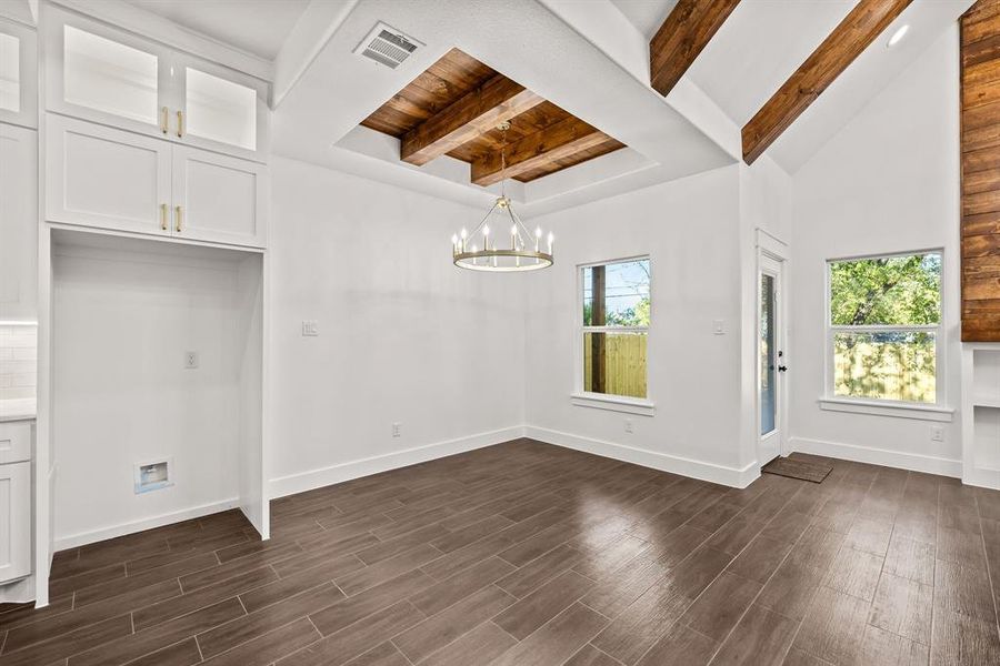 Unfurnished dining area with dark wood-style flooring and a chandelier Unfurnished dining area with dark wood-style flooring and a chandelier