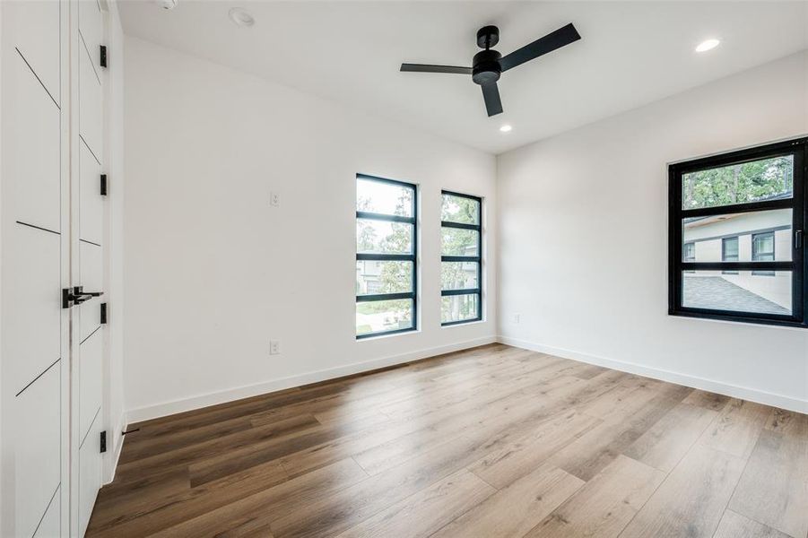 Unfurnished room featuring plenty of natural light, wood finished floors, ceiling fan, and recessed lighting Unfurnished room featuring plenty of natural light, wood finished floors, ceiling fan, and recessed lighting