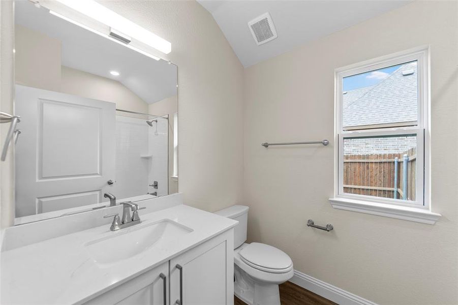 Bathroom featuring a white vanity with integrated sink, chrome faucet, and rectangular mirror