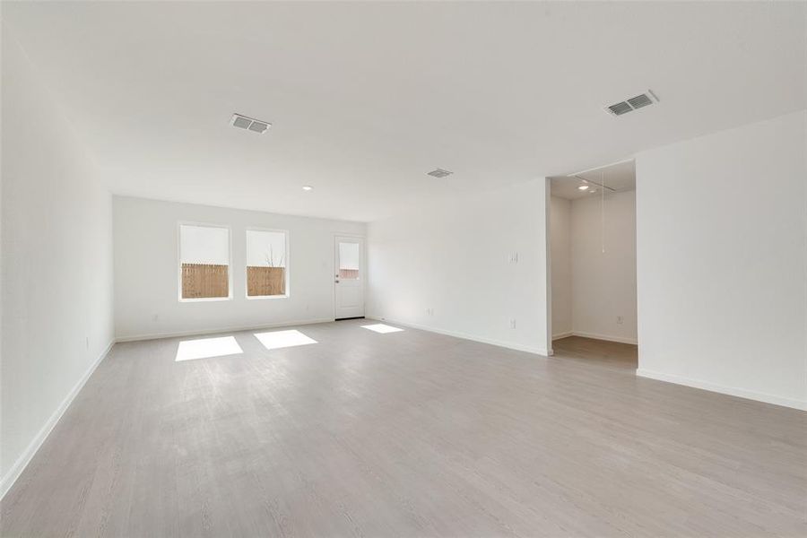 Empty room with attic access and light wood-style floors Empty room with attic access and light wood-style floors