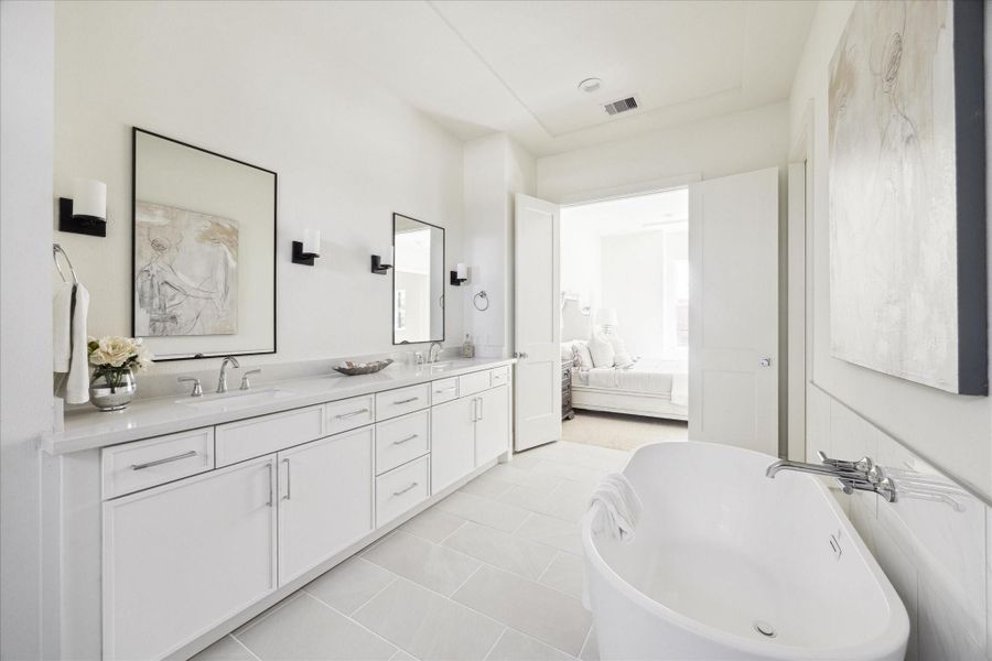 Spa Inspired Retreat – This primary bath features double vanities, quartz count tops, framed mirrors flanked by wall sconces adorned by a well-appointed bathroom chandelier. Bring your night to a perfect close in the stand-alone soaking tub. Spa Inspired Retreat – This primary bath features double vanities, quartz count tops, framed mirrors flanked by wall sconces adorned by a well-appointed bathroom chandelier. Bring your night to a perfect close in the stand-alone soaking tub.