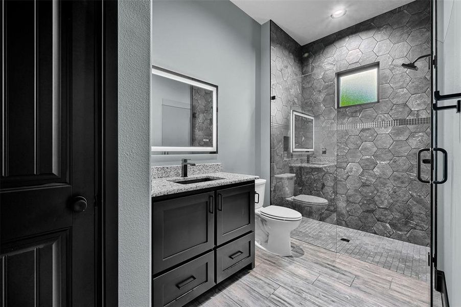 Bathroom with toilet, a shower stall, and vanity Bathroom with toilet, a shower stall, and vanity
