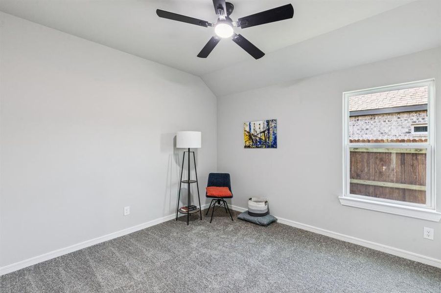 Living area featuring carpet floors, lofted ceiling, and a ceiling fan
