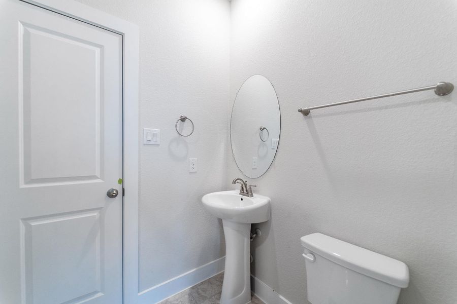 Half bathroom featuring toilet and baseboards