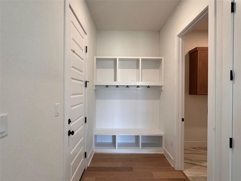 Mudroom featuring dark wood-style flooring and arched walkways