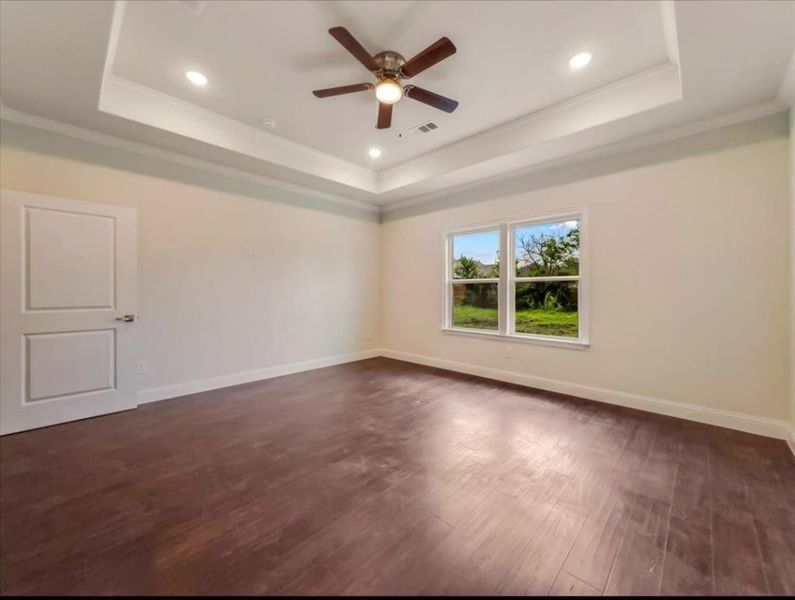 Unfurnished room featuring dark wood-style floors, a ceiling fan, recessed lighting, crown molding, and a raised ceiling Unfurnished room featuring dark wood-style floors, a ceiling fan, recessed lighting, crown molding, and a raised ceiling