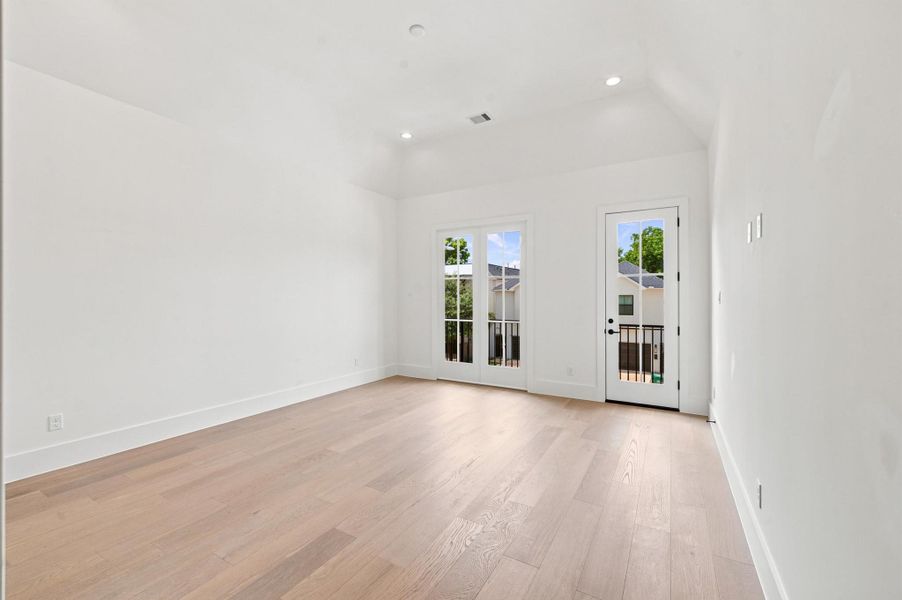 Primary bedroom features vaulted ceilings and private balcony access.