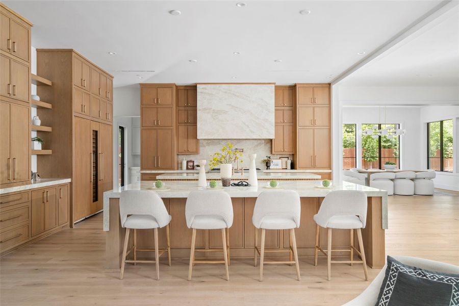 The kitchen features Taj Mahal quartzite, custom wood cabinetry, and a high end appliance package.
