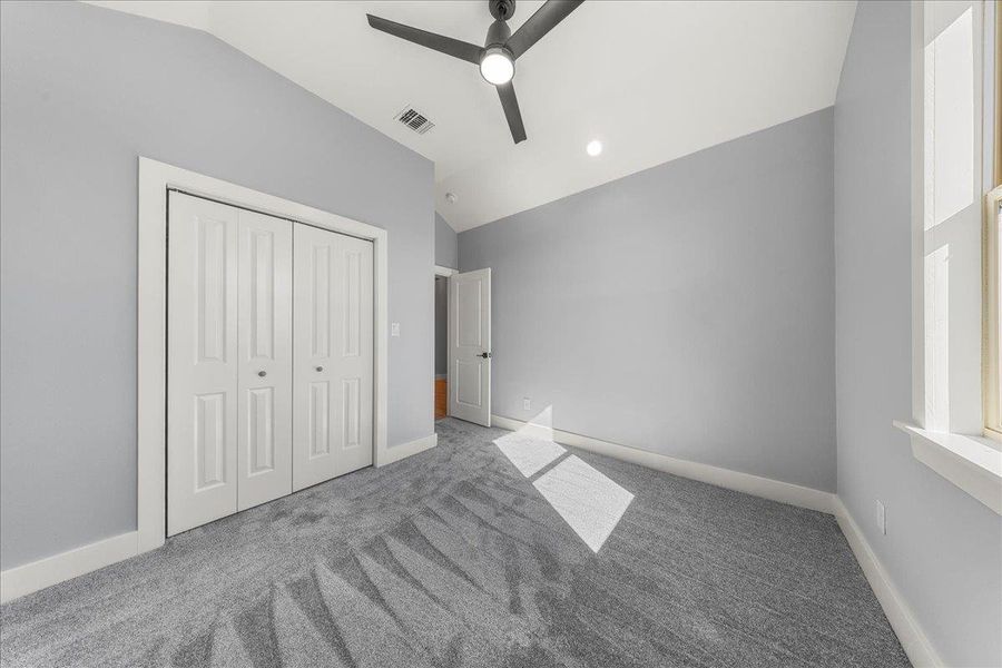 Unfurnished bedroom with lofted ceiling, carpet, ceiling fan, a closet, and recessed lighting Unfurnished bedroom with lofted ceiling, carpet, ceiling fan, a closet, and recessed lighting